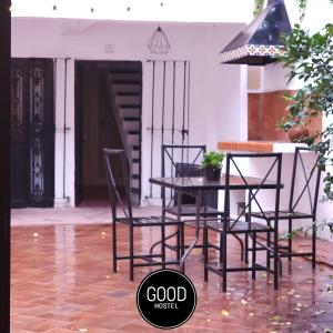 a table and chairs on a patio with water on the floor at Good Hostel in San Miguel de Allende