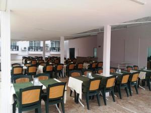 una habitación llena de mesas y sillas con grupos de mesas y sillas en MALİBU RESORT en Kemer