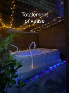 una vasca da bagno con luci e un cartello che legge i privilegi del bagno di Lovers Nest a Urbès
