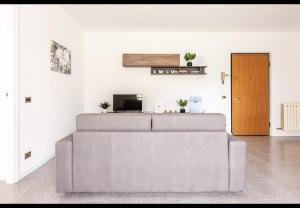 - un salon avec un canapé et une télévision dans l'établissement House of Lake Garda, à Castelnuovo del Garda