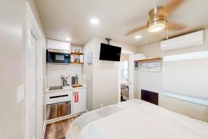 a small bedroom with a bed and a kitchen at Beach 5 Villas #B4 in Fernandina Beach