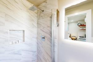 baño con ducha de mármol blanco en Beach 5 Villas #B4 en Fernandina Beach