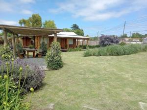 a garden with a house with a picnic table at Cabaña Via Verde in Tandil