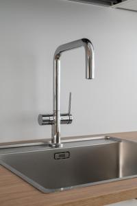 a stainless steel kitchen sink with a faucet at 2ndhomes Tampere "Puistotie" Apartment - 2BR Apt with Sauna and Balcony at Tammela Stadium in Tampere