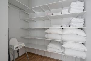 a closet filled with white towels on shelves at 2ndhomes Tampere "Puistotie" Apartment - 2BR Apt with Sauna and Balcony at Tammela Stadium in Tampere