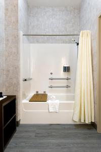 y baño blanco con bañera y ducha. en ClubHouse Hotel Sioux Falls, en Sioux Falls