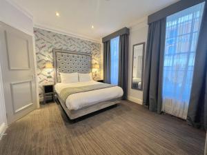 ロンドンにあるジ イートン タウンハウスの窓付きの部屋にベッド付きのベッドルーム1室があります。