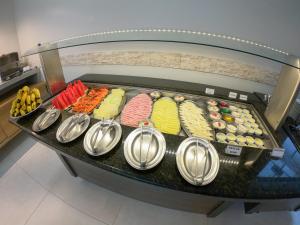 un buffet con diferentes tipos de repostería y cucharas en Lito Palace Hotel, en Registro