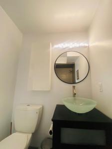 uma casa de banho com um WC branco e um espelho. em Modern studio near UCSF/Chase/Oracle Park em São Francisco