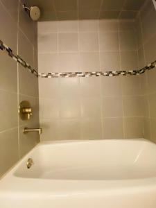 uma banheira branca na casa de banho com um chuveiro em Modern studio near UCSF/Chase/Oracle Park em São Francisco