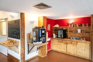 una cucina con pareti rosse e armadi in legno di Auberge de Jeunesse HI La Clusaz a La Clusaz