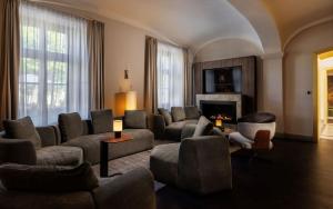 a living room with couches chairs and a fireplace at Anna Grand Hotel in Balatonfüred