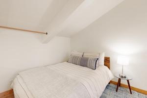 ein weißes Schlafzimmer mit einem Bett und einer Lampe in der Unterkunft Sunbeam Sanctuary in Ketchum