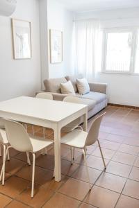 uma sala de estar com uma mesa e um sofá em Holidays, Arttyco 2 dormitorios 4 personas em Sierra Nevada