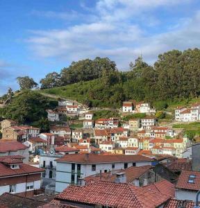 een groep huizen bovenop een heuvel bij COsTA CUDILLERO I in Cudillero