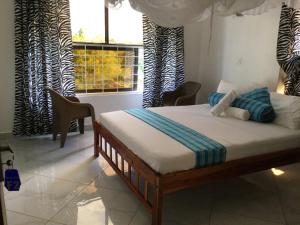 a bedroom with a bed in a room with windows at Silent Palms Villa in Galu