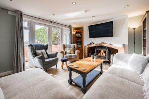 sala de estar con sofá y chimenea en Riverside Cottage - Norfolk Holiday Properties en Reedham
