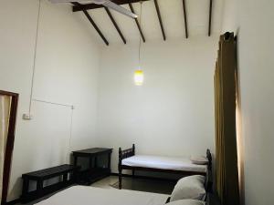 Habitación con 2 camas y un banco. en Aramba Resort, en Dondra West