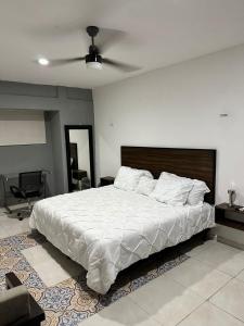 1 dormitorio con 1 cama grande y ventilador de techo en Apartamentos 31 en Progreso
