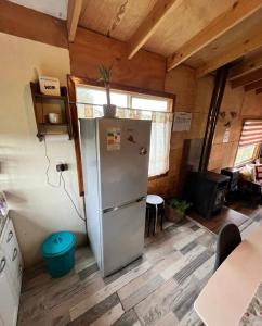 eine Küche mit einem Kühlschrank in der Mitte eines Zimmers in der Unterkunft Acogedora Casa de Campo Mocopulli in Dalcahue