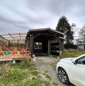 ein Haus mit einem davor geparkt in der Unterkunft Acogedora Casa de Campo Mocopulli in Dalcahue