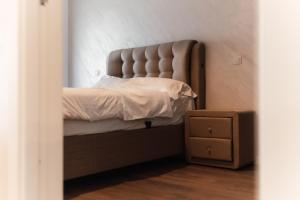 een bed met een gewatteerd hoofdeinde in een slaapkamer bij VIVO Residence Short Stay in Baia Mare