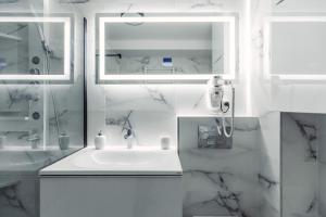 a white bathroom with a sink and a mirror at VIVO Residence Short Stay in Baia Mare