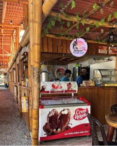 um carrinho de comida num restaurante com uma pessoa a preparar comida em PALOMINO PLAZA HOSTEL em Palomino