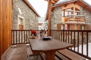 a wooden deck with a wooden table on a balcony at Chalet Laura in Saint-Marcel