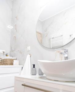 ein weißes Badezimmer mit einem Waschbecken und einem Spiegel in der Unterkunft Joanna's apartments in Alexandroupoli