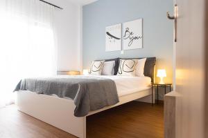Schlafzimmer mit einem Bett mit weißer Bettwäsche und Kissen in der Unterkunft Joanna's apartments in Alexandroupoli