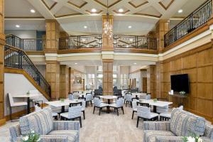 a restaurant with tables and chairs and a television at ClubHouse Hotel Sioux Falls in Sioux Falls