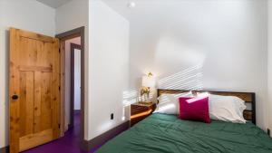 - une chambre avec un lit vert et un oreiller rouge dans l'établissement Mountain Majesty - Newly Remodeled, à Driggs