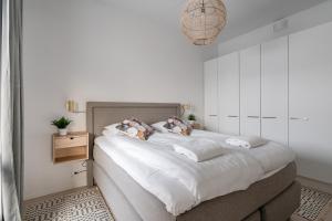 a white bedroom with a large bed with pillows at 2ndhomes Tampere "Sonetti" Apartment - Modern 2BR Apartment with Sauna and Balcony in Tampere
