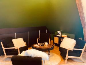 a room with chairs and a table and a green wall at La Green suite in Lys-lès-Lannoy