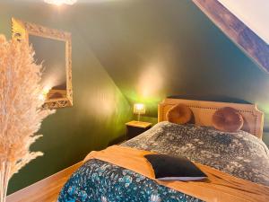 a bedroom with green walls and a bed with a mirror at La Green suite in Lys-lès-Lannoy