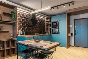 a kitchen with blue cabinets and a wooden table at CLUJSTAYS Urban Nest Central Apartment in Cluj-Napoca