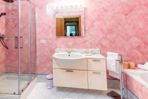 un bagno rosa con lavandino e doccia di Il Casato a Siena