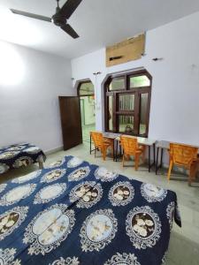 a bedroom with a blue and white bed and a table at Divisha PG House Sharing Beds Only for boys in Bareilly