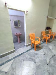 um grupo de cadeiras e um lavatório num quarto em Divisha PG House Sharing Beds Only for boys em Bareli