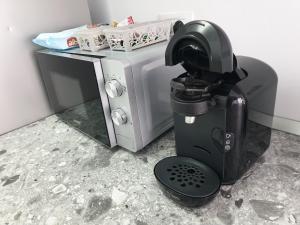 - une machine à café assise à côté d'un four micro-ondes dans l'établissement Cozy Studio Onesti, à Onești