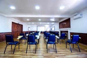クリチバにあるHotel Dan Inn Curitiba Centroの青い椅子とホワイトボードが備わる広い客室です。