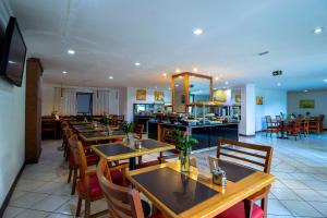 uma sala de jantar com mesas e cadeiras de madeira em Hotel Dan Inn Curitiba Centro em Curitiba
