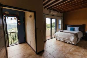 a bedroom with a bed and a large window at Casa 1800 Ataco Hotel Boutique in Concepción de Ataco
