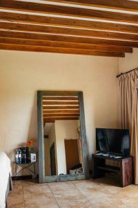 a mirror in the corner of a room with a tv at Casa 1800 Ataco Hotel Boutique in Concepción de Ataco