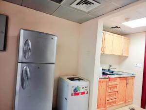eine Küche mit einem Kühlschrank und einem Mülleimer in der Unterkunft MBZ - Amazing Room "Men" in Abu Dhabi