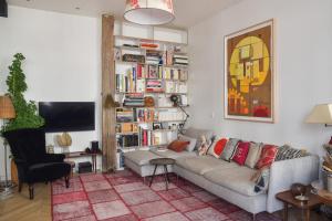 a living room with a couch and a book shelf at Contemporary T3 in the heart of Bastille Paris - Welkeys in Paris