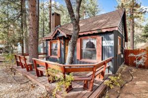 a tiny house with two benches on a deck at Bear Paw Cottage~ Hot Tub~ Resort Base Camp Cottage~ in Big Bear Lake