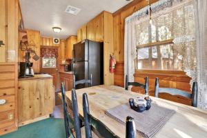 a kitchen with a wooden table and a refrigerator at Bear Paw Cottage~ Hot Tub~ Resort Base Camp Cottage~ in Big Bear Lake