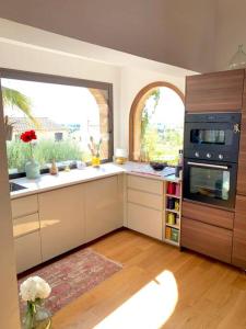 cocina con ventana grande y fogones en Charmante villa avec une âme., en Pignan